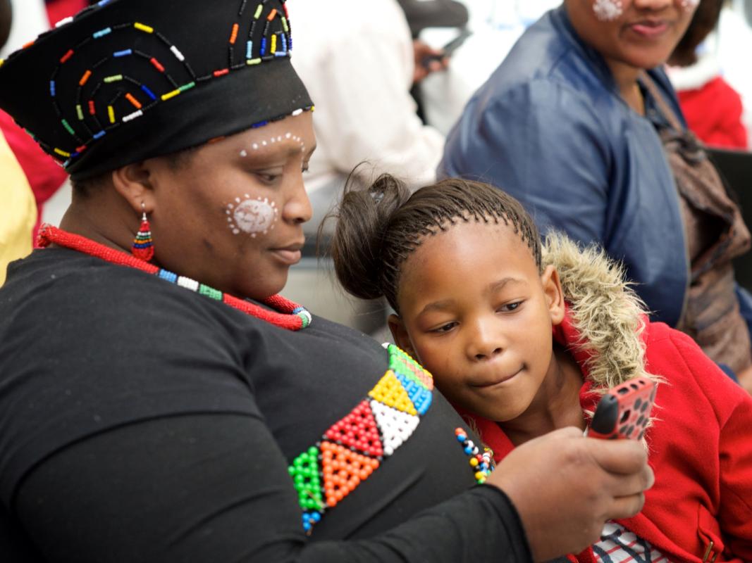 A person and a child looking at a mobile phone