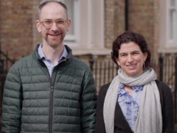  Lucie Cluver and Seth Flaxman are standing in front of a brick building.  
