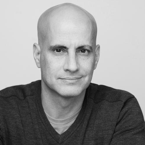 A black and white shot of Raeli, who is wearing a V-neck sweater