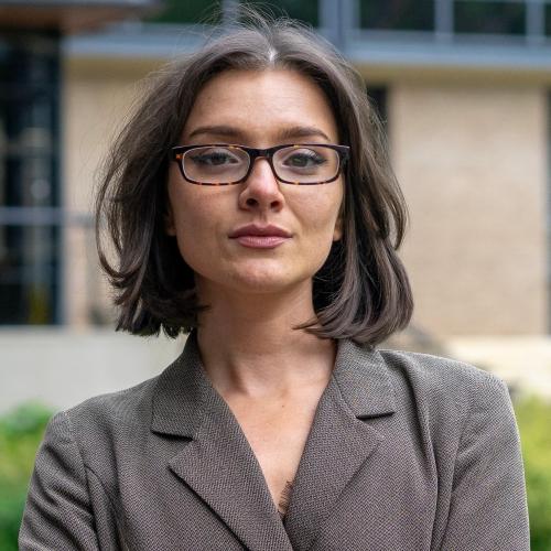 Aliyah Hurt has bobbed brown hair and is wearing a blazer and glasses.