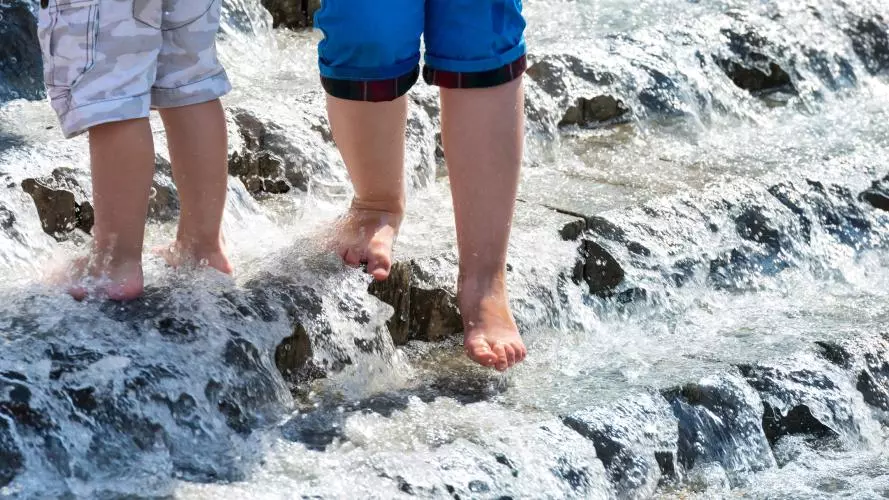 Water covered steps with two children's feet waking down them