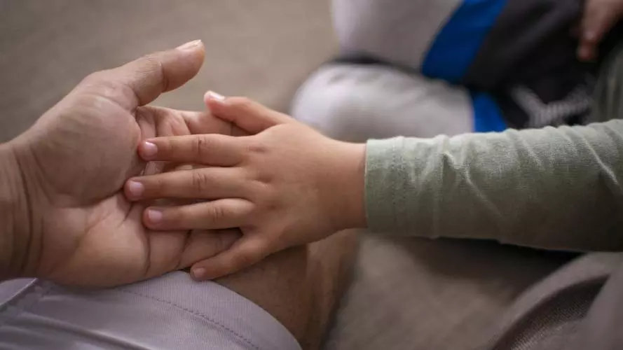 Child and adult holding hands