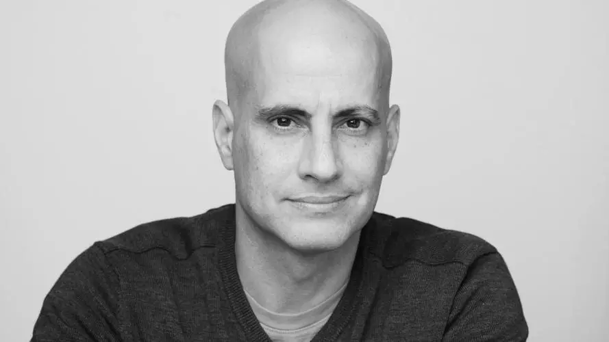 A black and white shot of Raeli, who is wearing a V-neck sweater