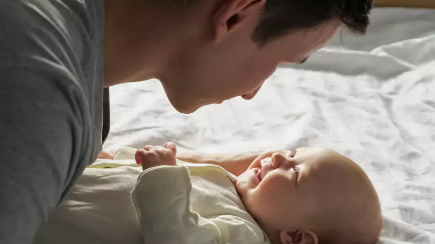 Parent looking at a baby smiling