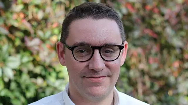 david humphries has short brown hair, glasses and wearing a white shirt.