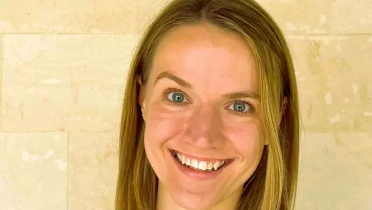 Susan Swingler has shoulder length blonde hair and is smiling. She's wearing a black top 
