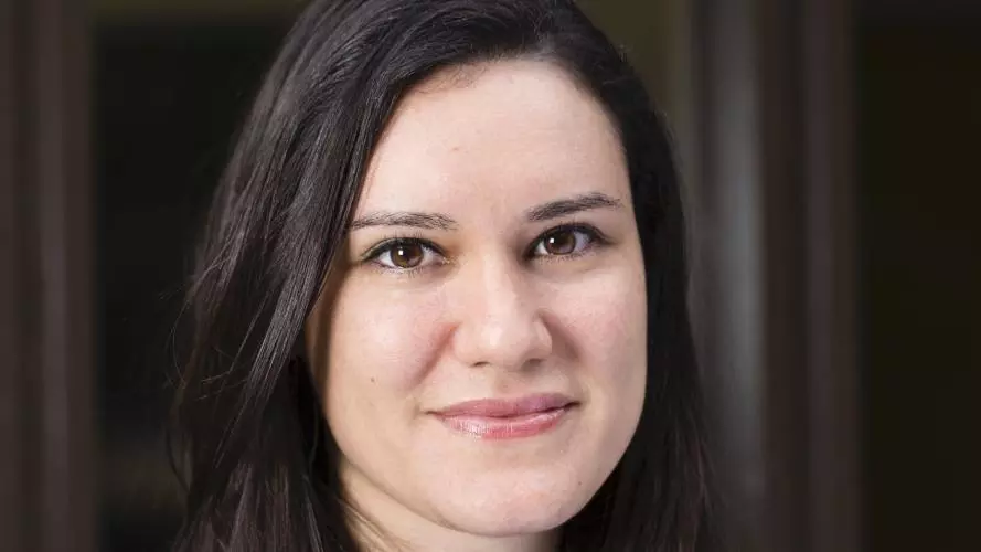 Dr Gabriela Pavarini has shoulder length dark hair, wearing a black top smiling gently at the camera.