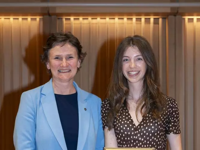 Two women standing next to each other, with one holding a certificate