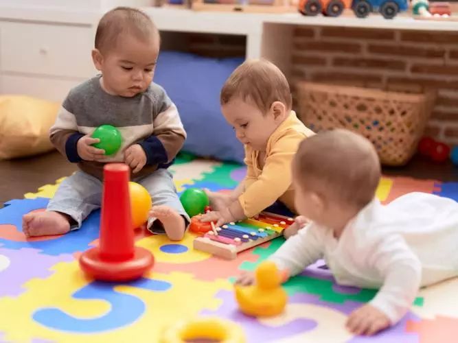 Three babies playing on a colourful floor matt. Photo credit: stock.adobe.com / Krakenimages.com