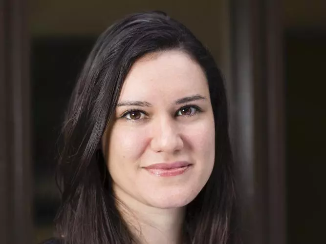 Dr Gabriela Pavarini has shoulder length dark hair, wearing a black top smiling gently at the camera.