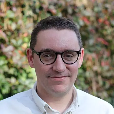 david humphries has short brown hair, glasses and wearing a white shirt.