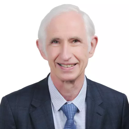 Robert  has grey hair and is smiling at the camera. He's wearing a shirt, tie and suit jacket 