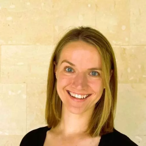Susan Swingler has shoulder length blonde hair and is smiling. She's wearing a black top 