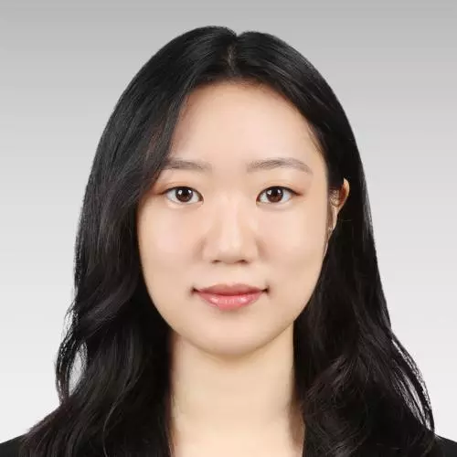 Solhee Han has long dark hair and is looking directly at the camera. She is wearing a white top and black jacket.