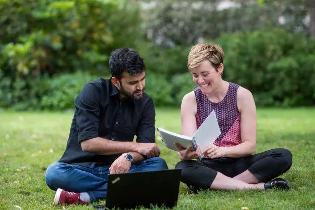 DSPI students sitting in a garden looking at a book